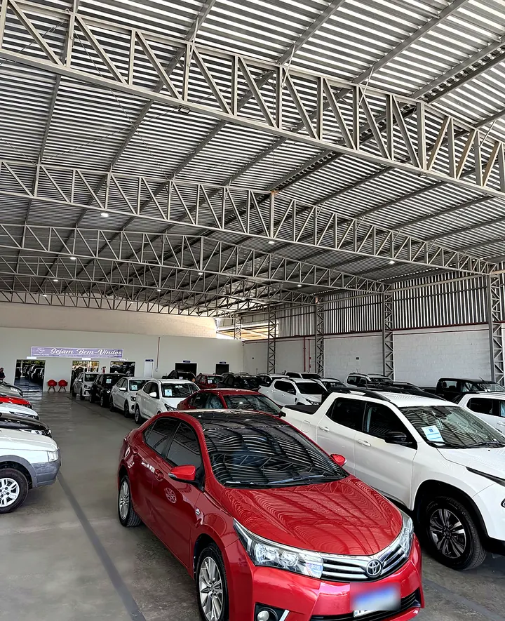 Sedã vermelho em destaque no salão da Abreu Autos